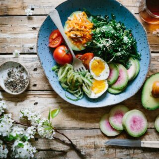 Vegetariánske recepty, vegetariánske jedlá. Miska plná zeleniny s vajcom na tvrdo, avokádom, paradajkami a listovou zeleninou.